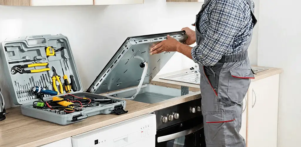 Handyman repairing a cooktop and checking wiring connections in Louisville, KY