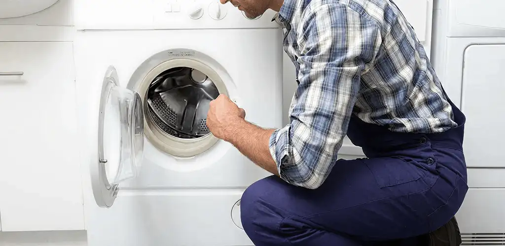 Handyman inspecting a dryer drum and internal parts for repair in Louisville, KY