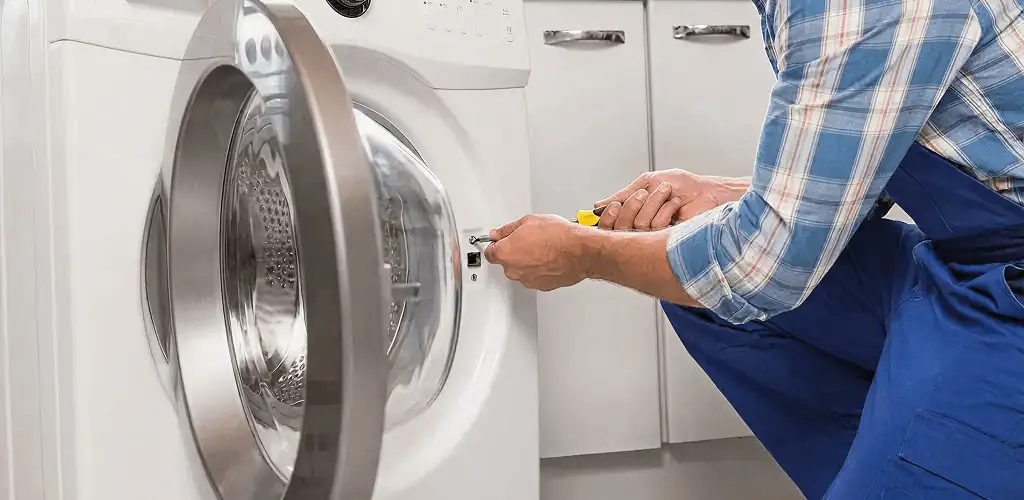 Handyman repairing a clothes dryer and checking electrical connections in Louisville, KY