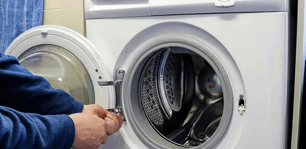 Washing machine repair handyman checking a front-load washer door and latch in Louisville, KY