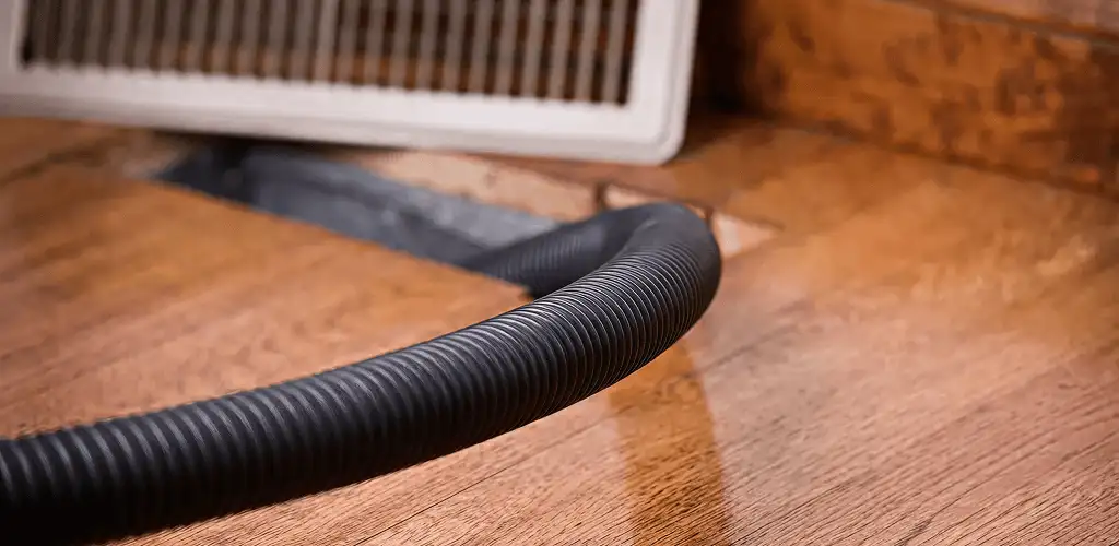Air duct cleaning hose inserted into a floor vent for ductwork cleaning in Louisville, KY