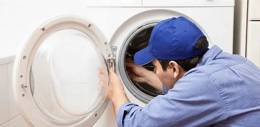 Washing machine repair handyman inspecting a front-load washer drum in Louisville, KY
