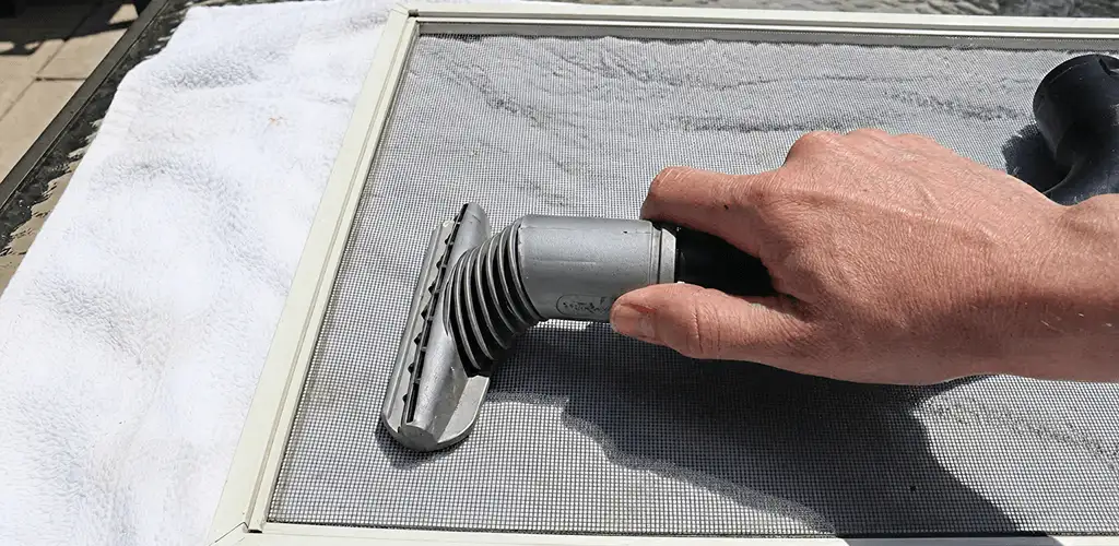 Window screen repair cleaning and fixing a damaged screen mesh in Louisville, KY